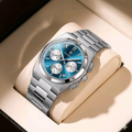 Silver watch with a blue face on a beige cushion